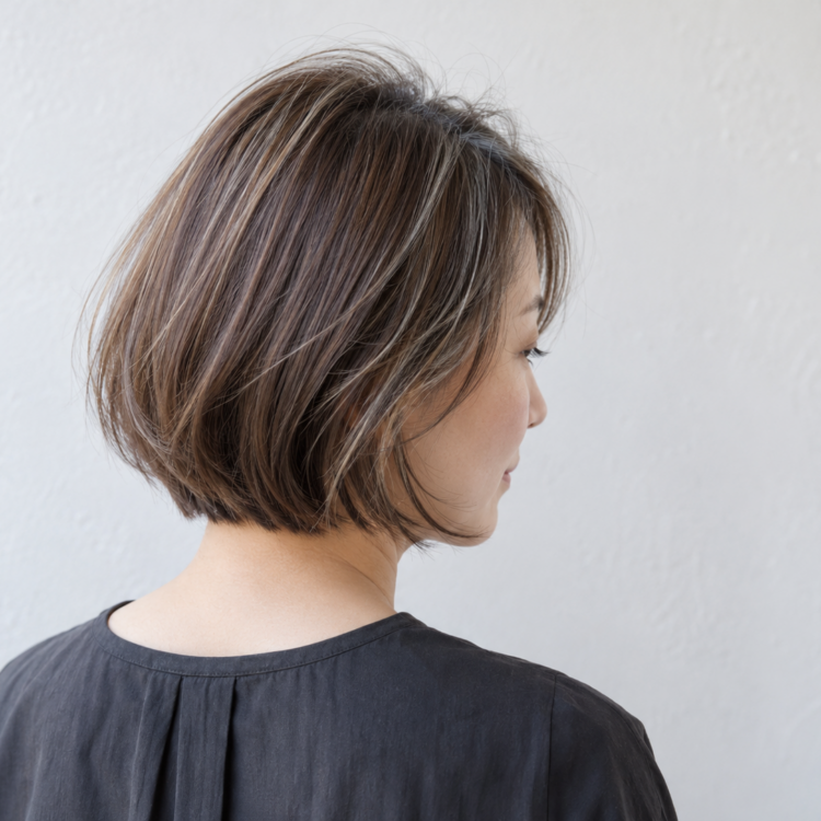 分け目付近に細いハイライトを配置した自然なブラウンのボブ