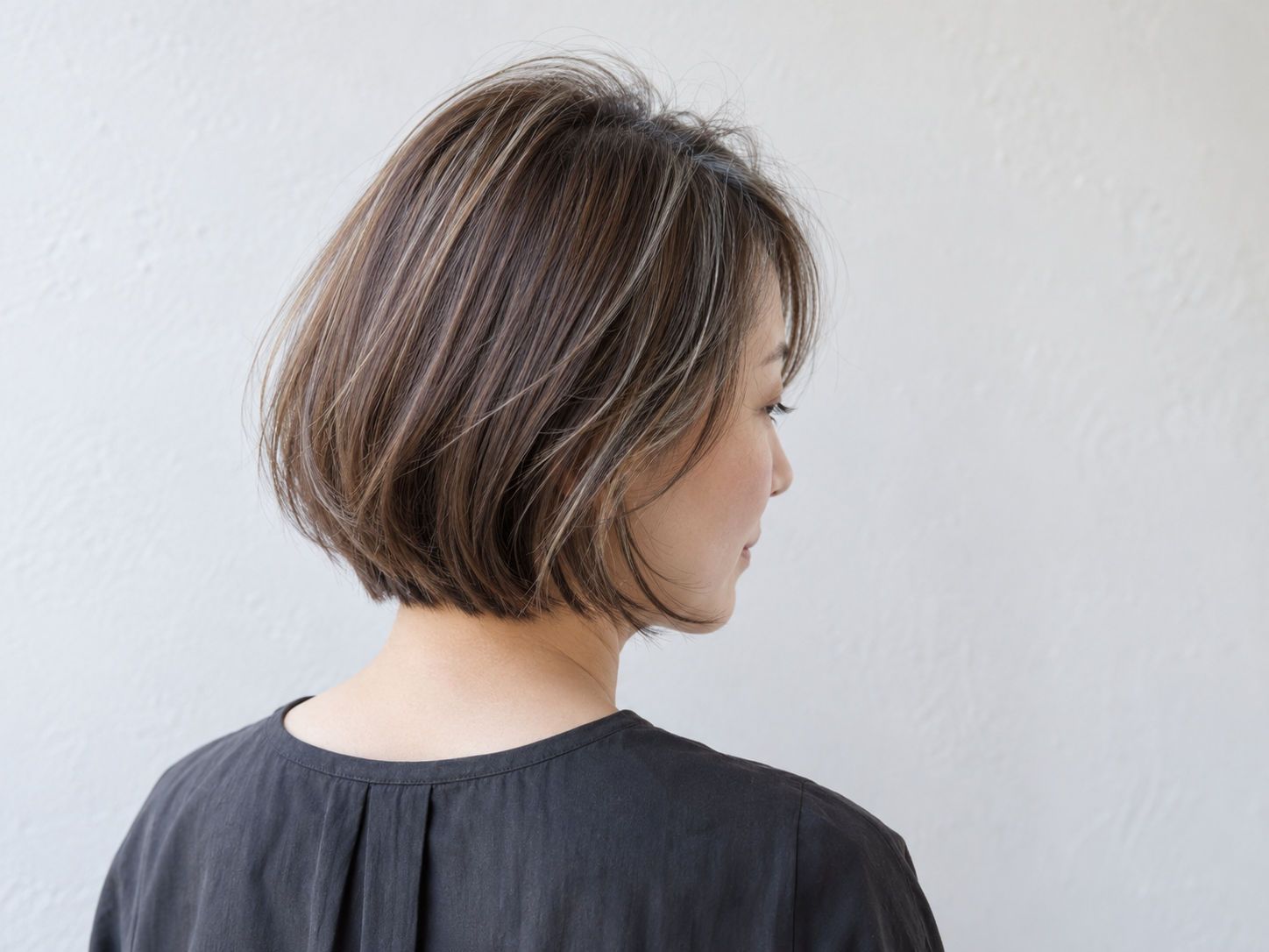 分け目付近に細いハイライトを配置した自然なブラウンのボブ