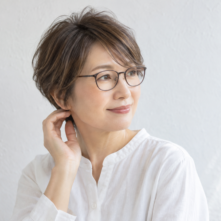 細いフレームのメガネと軽い前髪を合わせた50代女性の自然なショート